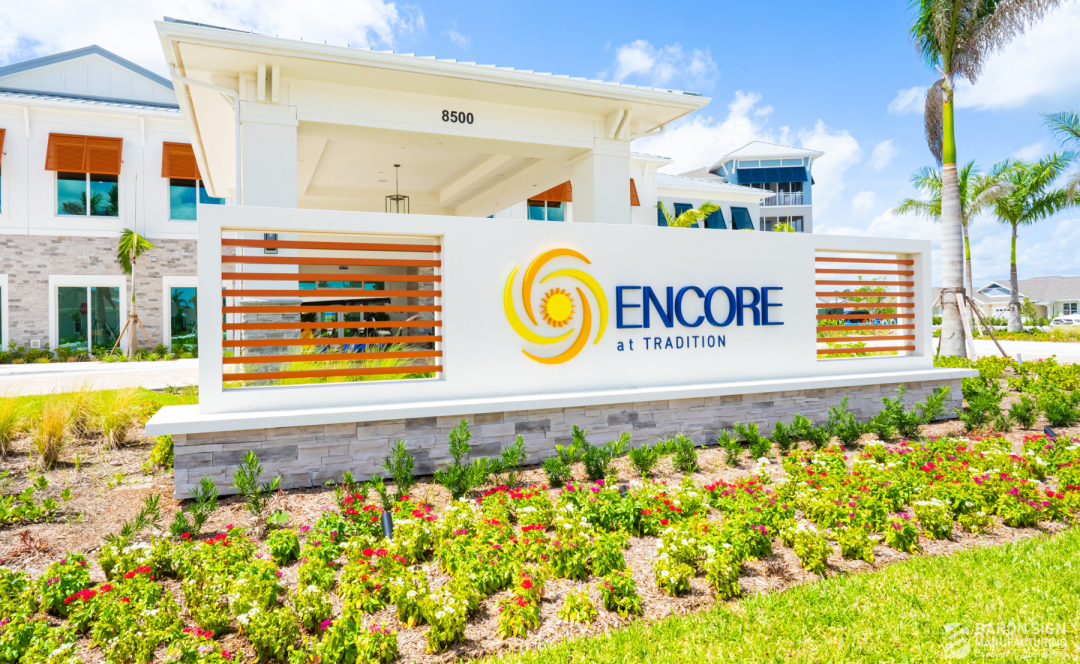 Encore at Tradition community entrance monument sign with custom horizontal orange louver screen wall and clubhouse at 8500