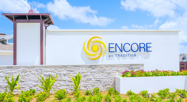 Encore at Tradition community entrance monument sign with custom horizontal orange louver screen wall and clubhouse at 8500