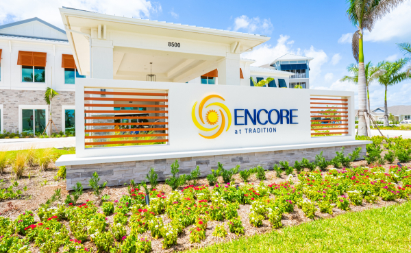 Encore at Tradition community entrance monument sign with custom horizontal orange louver screen wall and clubhouse at 8500
